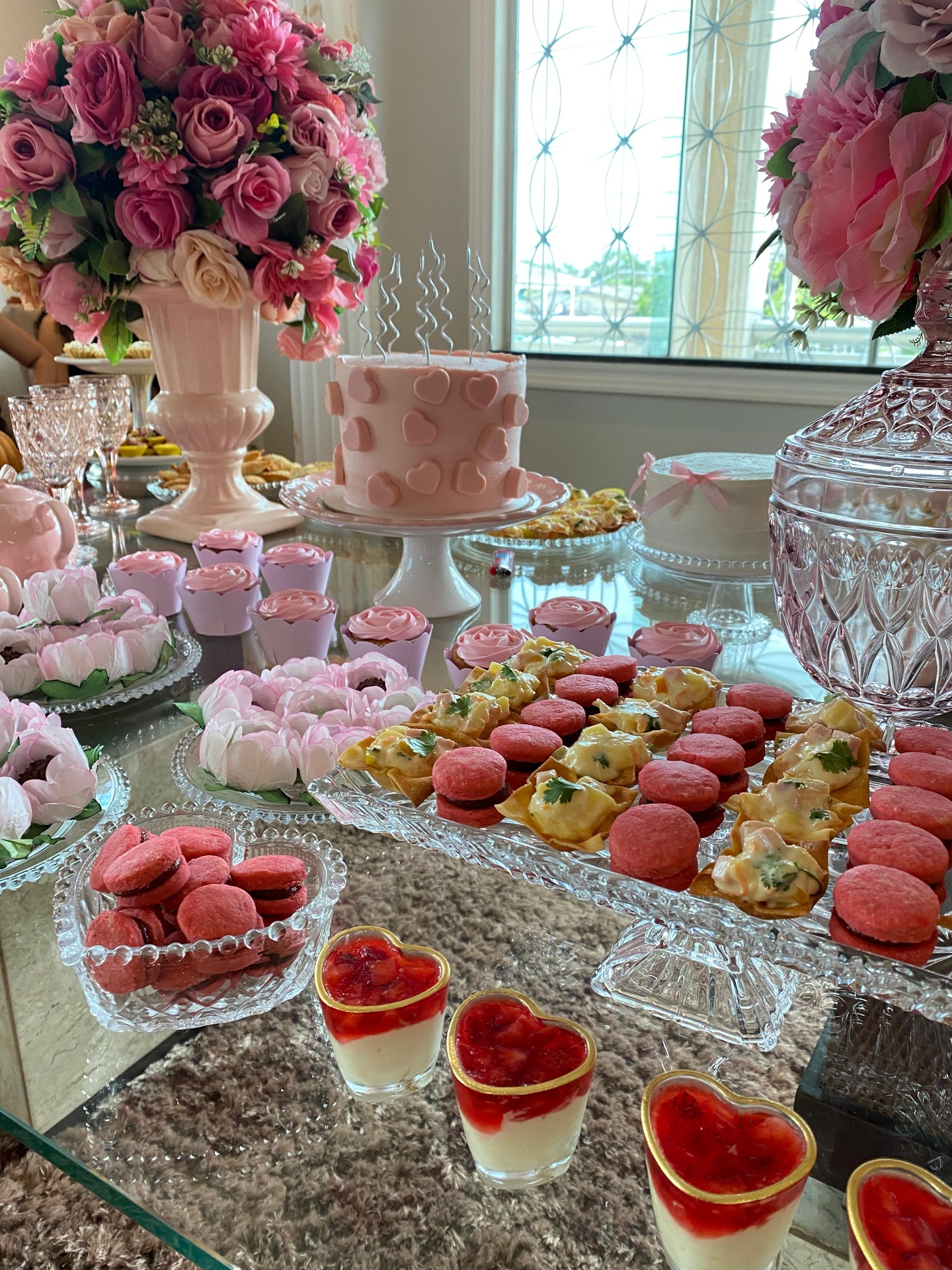Mesa de chá com bolo rosa, macarons e sobremesas