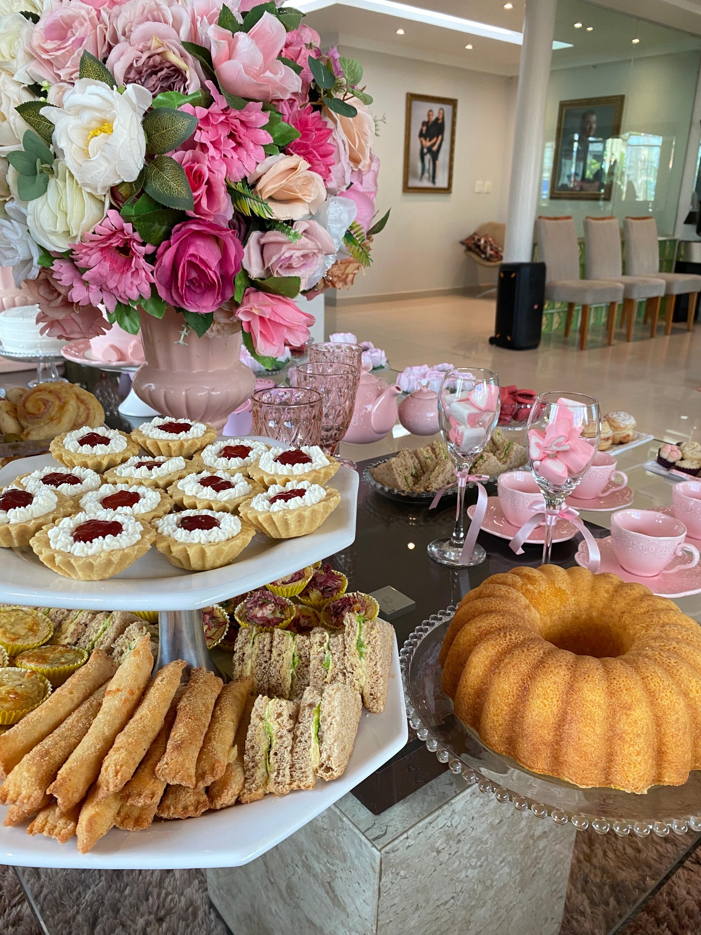 Mesa de chá com tarteletes, bolo e arranjo floral rosa